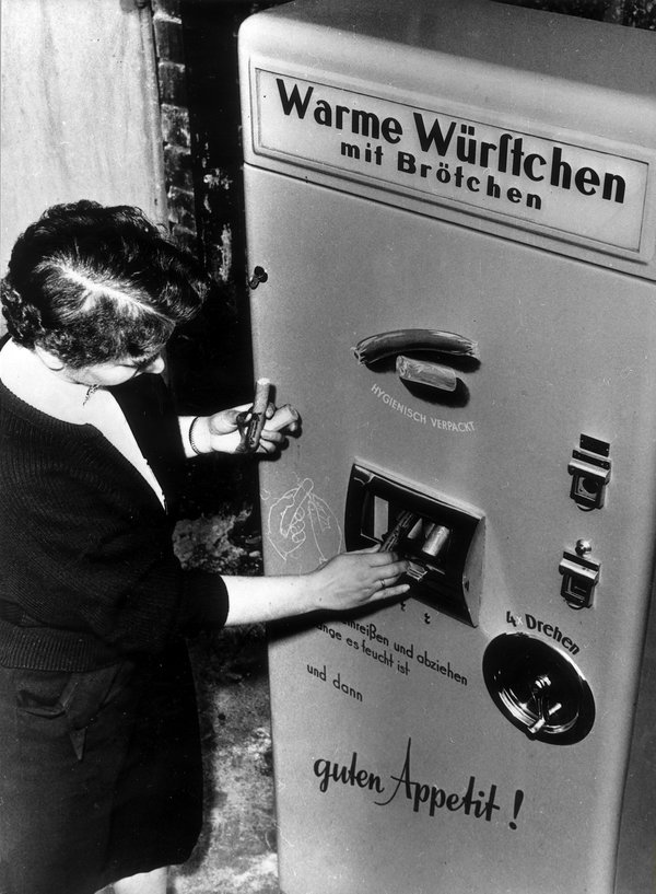 Germany, Berlin: Vending machine selling hot sausages presentet on the industries fair. 1954